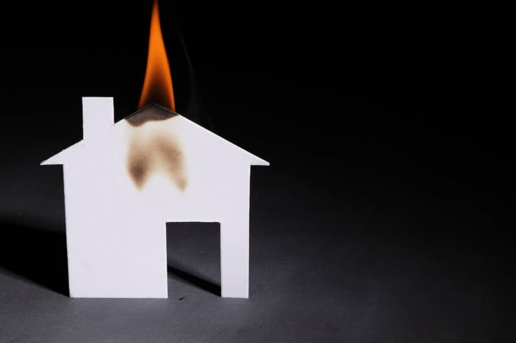 A paper house on fire representing the important of fire safety